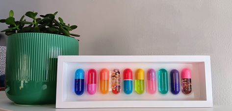 Colorful assortment of 10 chill pills in a white birch wood shadow box frame. Each pill (10) is hand-cast, pigmented, and hand painted in a fun variety of colors placed in a resin setting. This piece is sure to lighten up a home gallery wall or bring a pop of fun to a bookshelf in any office space. Variety and placement carefully selected to compliment each other and look great collectively. Pill Art, Donut Wall Art, Aesthetic Office, Wall Bookshelf, Colorful Wall Hanging, Bedroom Contemporary, Maximalist Wall, Maximalist Wall Art, Wall Ar