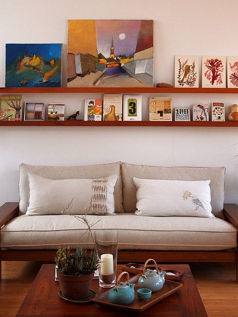 home of geninne zlatkis.  photo by gennine. Art Over Couch Ideas, Long Shelf Above Couch Modern, Shelf Over Sofa, Shelf With Picture Frames Above Couch, Long Shelf Above Couch Bohemian, How High To Hang Shelf Over Couch, Long Wood Shelf Above Couch, Art Shelf, Shelf Over Couch