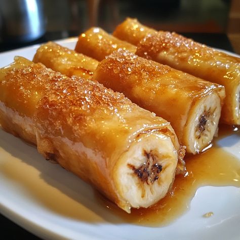 🍌🌟 Enjoy the sweet and crispy goodness of Turon—a delightful banana lumpia that's perfect as a snack or dessert! 😋✨ #Turon #BananaLumpia Turon (Banana Lumpia) Ingredients: Ripe bananas (4, sliced lengthwise) Brown sugar (1/2 cup) Lumpia wrappers (8) Oil for frying (as needed) Instructions: Sprinkle brown sugar over banana slices. Wrap each banana slice in a lumpia wrapper, sealing the edges with water. Heat oil in a pan over medium heat. Fry wrapped bananas until golden brown and crispy, ... Turon Banana, Banana Turon, Banana Lumpia, Lumpia Wrapper, Banana Slices, Ripe Bananas, Banana Slice, Frying Oil, Ripe Banana