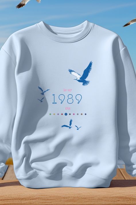 This design is inspired by Taylor Swift's 1989 era and was made FOR Swifties BY a Swiftie (it's me...hi). This sweater features a minimalist and iconographic design. The 10 dots at the bottom of the design each represent a different Taylor Swift album. The era being depicted in this design is accentuated. I made one of these for each era so that they can be bought in a set as a group gift! These would be a perfect and unique outfit to show up at the Eras Tour with! Taylor Swift Sweatshirt, Swiftie Gifts, Eras Tour Merch, Eras Tour Concert, Concert Merch, Unique Outfit, Taylor Swift 1989, Tour Merch, Group Gifts