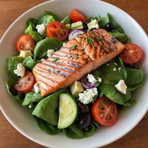 🥗 Greek-Style Salmon Salad Healthy and Flavorful Salad with Grilled Salmon and Fresh Mediterranean Ingredients Ingredients: For the Salmon: 4 salmon fillets (about 6 ounces each) 2 tablespoons olive oil 2 tablespoons fresh lemon juice 1 teaspoon dried oregano Salt and pepper to taste For the Salad: 6 cups mixed greens (such as arugula, spinach, and romaine) 1 cup cherry tomatoes, halved 1 cucumber, sliced 1/2 red onion, thinly sliced 1/2 cup Kalamata olives, pitted 1/2 cup feta cheese, cr... Mediterranean Ingredients, Grilled Salmon Salad, Oregano Salt, Salad Healthy, Salmon Salad, Green Tomatoes, Kalamata Olives, Spinach Salad, Greek Style