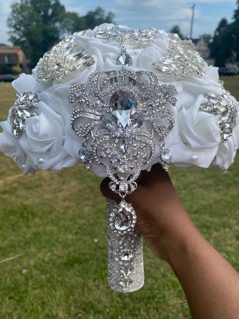 This luxurious bling bouquet is made with real touch artificial roses and silver brooches/gems. Roses are 3 inches wide. Size of bouquet shown is 10 inches wide at the top but can be ordered in a smaller size (8 inches). You may choose any color(s) for your rose bouquet. Please list any additional colors for your roses under "personalization." It will allow you to type a note to me. Please message me if you do not see your color(s). Brooches may vary but are available in silver, gold, or rose go Silver Wedding Bouquets, White Silver And Black Wedding, Long Wedding Bouquets Brides, Bouquets With Crystals, Bouquet For Bride, Luxurious Flower Bouquets, Gray Wedding, Rose Bouquet With Glitter, Blinged Out Bouquets