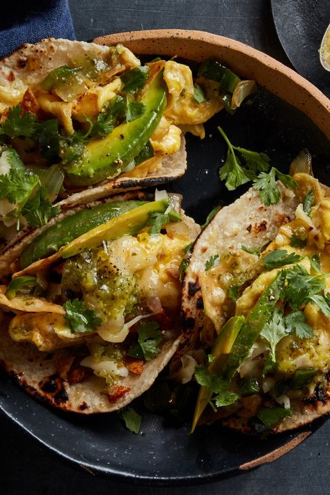 6 large eggs Kosher salt6 corn tortillas2 tablespoons vegetable oil1 cup tortilla chips, broken if very large½ cup diced onion1 cup diced, seeded poblano pepper¼ cup chopped cilantro2 ounces pepper jack cheese, grated (3/4 cup)½ avocado, pitted, peeled and sliced Salsa, for serving Breakfast Tacos Recipe, Nyt Cooking, Breakfast Tacos, Taco Recipes, Scrambled Eggs, Melted Cheese, Tortilla Chips, Onions, Mexican Food Recipes