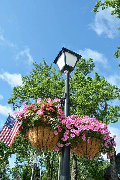 Hanging baskets with flags on lamp post in charming town of Blowing Rock, NC | ©homeiswheretheboatis.net #mountains Plants Around Lamp Post, Flowers Around Light Post, Landscaping Around A Lamp Post, Lamp Post Flower Bed, Outdoor Lamps Whit Pole, Hanging Flower Baskets, Hanging Flowers, Small Garden Design, Outdoor Post Lights