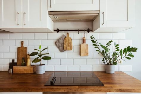 Kitchen brass utensils, chef accessories. Hanging kitchen with white tiles wall and wood tabletop.Green plant on kitchen background Kitchen Background, White Subway Tiles, Wood Counter, White Modern Kitchen, Wood Countertops, Kitchen Tile, Countertop Materials, White Tiles, Kitchen Counter