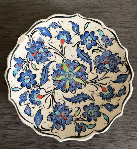 Add a touch of Turkish culture to your home with this beautiful collector plate. The 7" round ceramic plate features a stunning hand-painted floral pattern in shades of blue, making it a perfect addition to any collection. The plate is from Kutahya, Turkey and has a vintage feel to it, adding to its charm. This Turkish ceramic wall plate is a unique piece of art that will add an ethnic touch to any room. The plate is made of high-quality ceramic and is perfect for displaying on a wall or table. Its brand is handmade, and it has a diameter of 7 inches. This collector plate is a must-have for anyone who loves collecting unique pieces of art. BEAUTIFUL HAND PAINTED DESIGN ~ BLUE, RED, GREEN & BLACK ~ SCALLOPED EDGE 2 CHIPS ON THE FRONT & 1 CHIP ON THE BACK ~ STILL VERY BEAUTIFUL  7" dia. x 1 Turkish Theme, Turkish Ceramics, Turkish Culture, Turkish Art, Ceramic Plate, Wall Plate, Ceramic Plates, Scalloped Edge, Art Beautiful