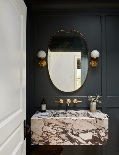 Dark paneling and bold marble vanities are our new favorite combo! Black and white marble floating sink + moody bathroom ideas + wall mount faucet in bathroom | Amber Interiors, Photography by Tessa Neustadt Floating Marble Sink, Moody Powder Room, Floating Sink, Marble Sinks, Alien Planet, Black And White Marble, Deco Boheme, Downstairs Bathroom, Small Bath