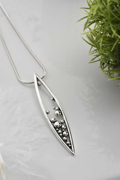 Inspired by a seed pod bursting open this marquee shaped pendant is handmade in solid sterling silver. It features a hidden bail at the back of the piece, that creates a really elegant and streamlined look.  MATERIALS & PROCESS  ♢ Solid sterling silver  ♢ To create this pendant I constructed a master from solid silver, forming each circle from silver wire by hand and melting the silver into little balls. When the master was perfect I had a mold made and cast it into solid sterling silver. This i Hidden Bail Pendant, Marquise Pendant, Creative Necklace, Seed Pod, Handmade Silver Jewellery, Handmade Pendant Necklace, Cardboard Jewelry Boxes, Jewelry Artist, Silver Jewelry Design