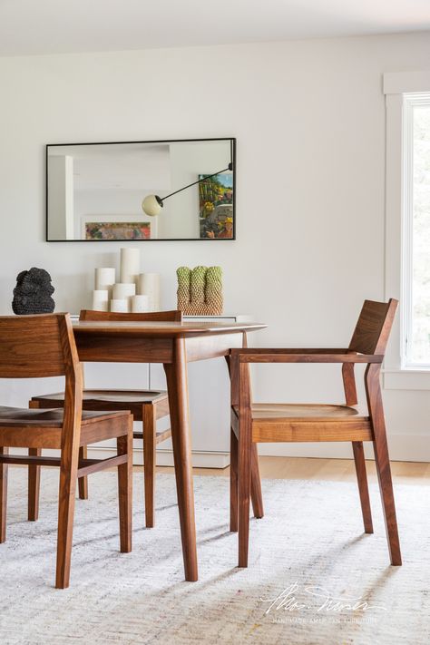 A walnut dining table and dining chairs are in a contemporary home with white walls and neutral rugs. New England Dining Room, Interior Design Inspiration, American Made, Furniture Making, New England, The Beauty, Patina, Dining Room, Design Inspiration