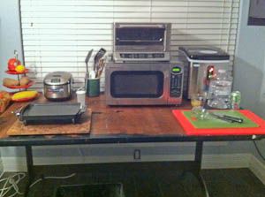 Makeshift kitchen with countertop appliances Make Shift Kitchen During Remodel, Kitchen Remodel Cost Estimator, Makeshift Kitchen, Temporary Kitchen, Living In A Hotel, Kitchen Setup, Granite Kitchen Counters, Truck Living, Small Studio Apartment Decorating