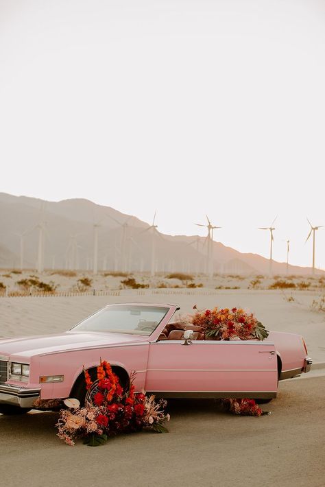 Pink Cadillac convertible in bold, bright tropical flowers. Palm Springs Windmills elopement styled shoot. Valentines Day inspiration. #floralcar #convertibleflorals #pinkcadillac #pinkconvertible #pinkcar #pinkconvertiblecadillac #palmspringselopement #palmspringswedding #palmspringselopementideas #retroelopement #getawaycar #weddingcar #palmspringsweddingshoot #styledshootpalmsprings #palmspringsconvertible #palmspringscar #convertiblestyledshoot #pinkcarshoot #pinkconvertiblestyledshoot Palm Springs Windmills, Retro Elopement, Vintage Palm Springs, Palm Springs Aesthetic, Cadillac Convertible, Elopement Styled Shoot, Classic Car Photoshoot, Orange Wedding Colors, Floral House