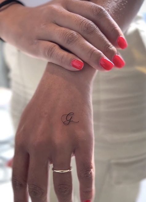 Hand Tattoos For Women Initials, Small Letter Hand Tattoo, One Letter Tattoo Placement, Small G Tattoo, G Finger Tattoo, Hand Initial Tattoo, Initial Hand Tattoo, Small Letter Tattoo On Finger, E Tattoos