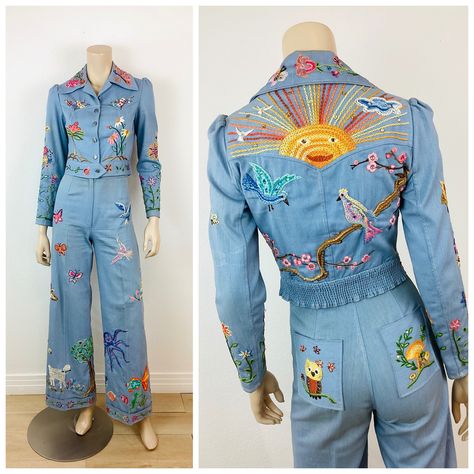 Vintage 1970s Embroidered Denim Jacket & Pants Set total work of art! hand made & hand embroidered! set includes  jacket & bellbottom pants made of light blue cotton denim material heavily embroidered with whimsical creatures jacket has button closures at front puff shoulder fits at waist high waisted pants bell bottom leg covered in colorful embroidered sun with rays, birds, flowers, apple tree, giraffe, octopus, mermaid, cherry blossoms, scorpion, skunk, lamb in French knot, butterflies and co Vintage School Outfits, Embroidered Jackets For Women, Bellbottom Pants Outfits, Funky Suits, Denim Pantsuit, Nudie Suit, 70s Fashion Vintage, Whimsical Clothing, Suit Aesthetic