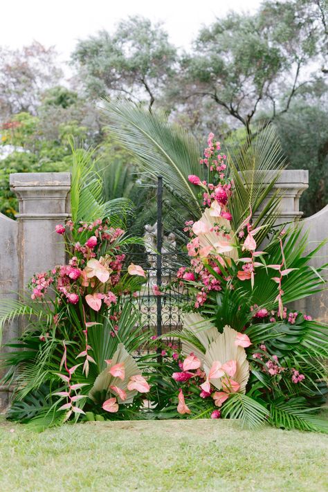 Hawaiian luxury wedding backdrop of tropical foliage and pink florals #WeddingChicks #HawaiianWedding #pinkceremonybackdrop #pinkceremonyarch #tropicalwedding #tropicalweddingbackdrop Tropical Arches Wedding, Tropical Flower Decoration, Tropical Backdrop Wedding, Tropical Wedding Alter, Tropical Floral Installation, Tropical Florals Wedding, Tropical Chuppah, Indian Wedding Modern, Tropical Flower Backdrop