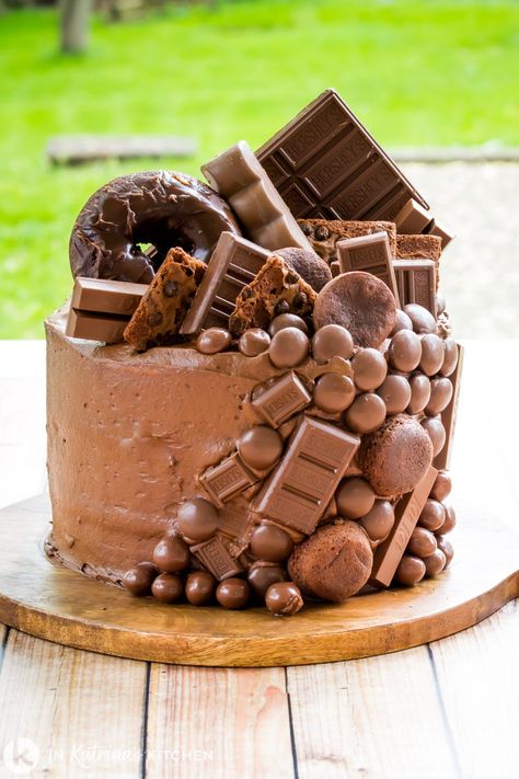 Customize this Chocolate Overload Cake with your favorite chocolate candy, cookies, brownies, and even doughnuts. Chocolate in every bite! PRINT and PIN the recipe at In Katrina's Kitchen today! Chocolate Overload Cake, Chocolate Bar Cakes, Chocolate Candy Cake, Cake Recipes At Home, Inside Cake, Candy Birthday Cakes, Chocolate Cake Designs, Chocolate Frosting Recipes, Homemade Chocolate Cake