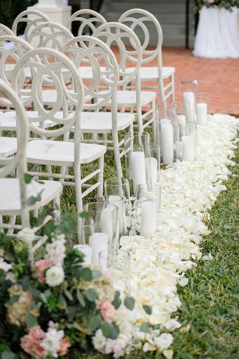 Adding flower petals and candles to your aisle creates such a romantic look. This aisle look was the perfect complement to this historic mansion wedding venue. To learn more and take a tour visit myweddingscout.com. Venue: Woodbine Mansion. Photo: Stacy SMS Photography. Petals Lining Aisle, Romantic Outdoor Wedding Ceremony, Outdoor Wedding Ceremony Aisle, Wedding Venues In Texas, Woodbine Mansion, Mansion Wedding Venues, Romantic Outdoor Wedding, Austin Wedding Venues, White Chairs