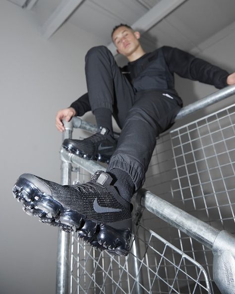 Stylish 2019 Nike Air Vapormax 3 sneakers in a black and dark grey colour. Man sitting on railings with black trackies showing Nike trainers. Dark Grey Colour, Vapor Max, Nike Vapormax, Man Sitting, Nike Trainers, Air Vapormax, Dark Grey Color, Nike Air Vapormax, Grey Colour