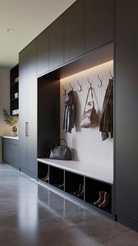 This contemporary mudroom showcases a perfect blend of style and practicality, making it an excellent choice for modern families or professionals seeking an organized entryway. The dark cabinetry provides a striking contrast against the illuminated backdrop, highlighting the well-placed hooks for coats and bags. The bench offers a comfortable spot for putting on shoes, while the open cubbies beneath provide accessible storage for boots and other... Mud Room Entrance Ideas, Mudroom Interior Design, Shoe And Jacket Storage Entry Ways Diy, Indoor Storage Room, Mud Room Shoes Storage Ideas, Mud Room Modern, Entrance Mudroom Ideas, Tiny Mudroom Ideas Entryway, Show Storage Ideas