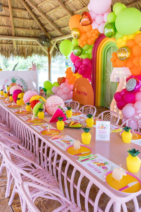 TWOtti Frutti-themed tablescape by ChrisFête Events, featuring pineapple cups, fruity centerpieces, and vibrant balloon decor. Tropical 1st Birthday Party Girl, Fruits Theme Birthday Party, Tropical Kids Party, Fruit Party Ideas, Twotti Fruity Party, Fruit Themed Birthday Party, Birthday Tablescape, Luxury Event Decor, Twotti Fruity