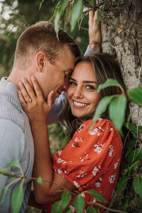 Couple standing against tree posing man resting his forehead against woman temple Couple Poses With Tree, Couple Poses In Park, Couple Bridge Photos, Tree Poses Photography, Couple Same Height, Couple Park Photoshoot, Height Difference Couple Poses, Couple Sitting Poses, Couple Under Tree