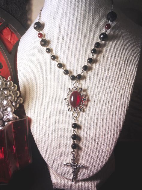 25 inch necklace with stainless steel chain and 3 1/2 inches of black and red glass beading on either side. Central pendant with red acrylic set and zinc alloy rose cross Made with love by Sacke & Sugar in Chattanooga, TN. Jewelry has small parts and is not intended for children. Follow us on Instagram for updates and sales: @sacke_and_sugar Cross Choker Gothic, Vampire Gothic Fashion, Calista Core, Vampire Goth Fashion, Gothic Accessories Jewellery, Baddie Jewelry, Vampire Accessories, Vamp Goth, Vampire Cosplay