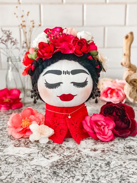 White painted pumpkin with braided black yarn hair. Barbie Themed Pumpkin, Cosmetology Pumpkin Decorating, Frida Kahlo Pumpkin Carving, Frida Pumpkin Painting, Frida Pumpkin, Frida Kahlo Pumpkin, Barbie Pumpkin, Pumpkin Paintings, Halloween Pumpkin Crafts