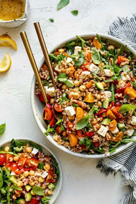 This Greek Farro Salad gives classic Greek salad a hearty twist! Farro is tossed with cherry tomatoes, cucumber, roasted red bell pepper, feta, & arugula & it's all finished with a simple Greek dressing. Not only is it absolutely delicious & easy to make, this Mediterranean farro salad is incredibly versatile – serve it warm or cold, as a side dish or plant-powered main, or meal prep it for the best weekday lunches. Naturally vegetarian, easily dairy-free & vegan. #farrorecipes #farrosalad Greek Farro, Classic Greek Salad, Greek Night, Chickpeas Salad, Greek Salads, Salad Arugula, Roasted Red Bell Pepper, Farro Salad Recipes, Weekday Lunches