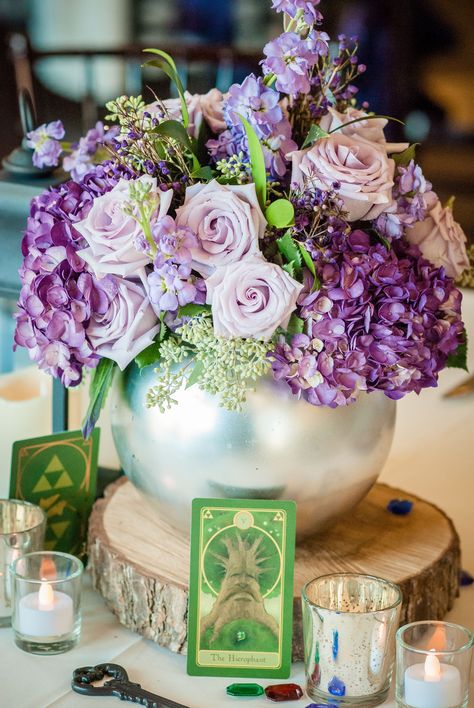 My Mother-in-Law created some amazing centerpieces. Most were variations of the same design: wood plank bases, mercury glass candle holders (with LED candles), a sprinkling of plastic rupees, Zelda-themed tarot cards, iron keys, and a vase with flowers. Zelda Themed Wedding, Card Box Diy, Constellation Wedding, Zelda Party, Video Game Wedding, Zelda Wedding, Gamer Wedding, Nerd Wedding, Jasmine Wedding