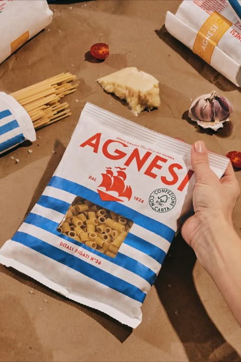 One of the most recognizable supermarket pasta brands is celebrating its 200th anniversary with a charming upgrade from Auge Design. Agnesi's nautical new look is super fitting of the Italian company's lengthy legacy, but also has enough retro-modern charm that we could imagine it popping up in a Wes Anderson movie (which is definitely a thing right now). Pasta Packaging Photography, Italian Packaging Design, Italian Food Packaging, Pasta Branding, Pasta Packaging Design, Supermarket Branding, Italian Packaging, Pasta Packaging, Wes Anderson Movie