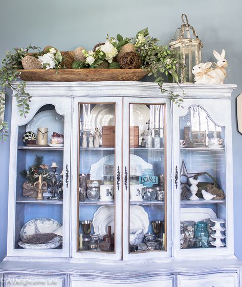 large dough bowl filled with Spring decor on A Delightsome Life. #adelightsomelife #diningroom #hutch #chinacabinet #ideas #springdecor #inspiration #doughbowl #rabbits #curiositycabinet #decorsteals #ironstone Top Of Hutch Decor, Wooden Bowls Decor Ideas, Wooden Bowls Decor, Armoire Decor, Large Dough Bowl, China Cabinet Decor, Diy French Country Decor, French Country Rug, Decorating Above Kitchen Cabinets