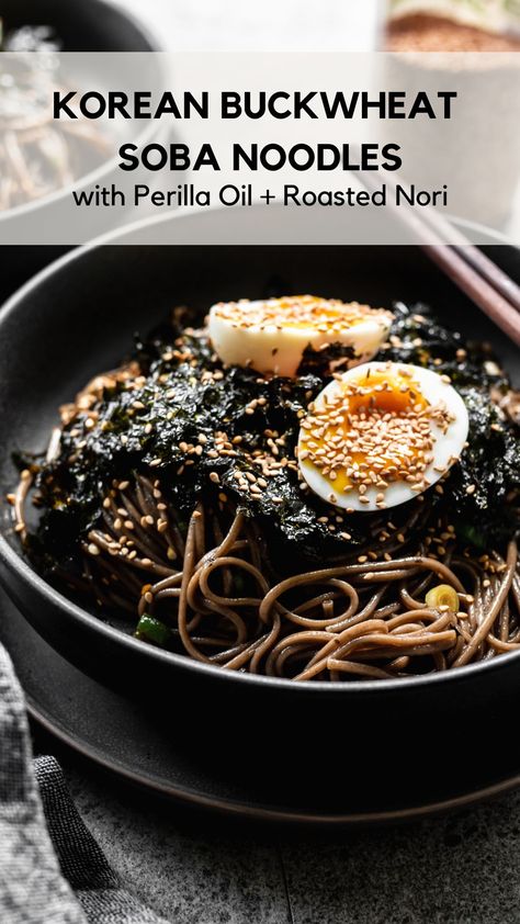 A bowl filled with Korean buckwheat soba noodles with crushed roasted nori or memil guksu Perilla Oil Recipe, Korean Soba Noodle Recipe, Earthy Meals, Korean Buckwheat Noodles Recipe, Korean Cold Noodles Recipe, Vegetarian Cold Lunches, Buckwheat Soba Noodle Recipe, Cold Noodle Recipes, Seaweed Snacks Recipes