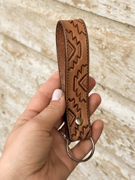 This tooled leather keychain is the perfect western accessory to keep track of your keys & make a statement, all at the same time. This keychain is handcrafted from scratch & tooled with care. It is finished with a silver rivet & stainless steel keyring. Due to the handmade nature of this item, the actual product may vary from the photo. All keychains are made to order, so they will be unique. Leather Flowers Pattern, Wood Burning Leather Ideas, What To Do With Leather Scraps, Western Gifts For Women, Leather Strips Crafts, Leather Craft Projects Ideas, Leather Craft Ideas Handmade Gifts, Leather Work Patterns, Tooled Leather Design Pattern