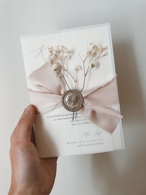 Celebrate your love story with a custom-designed wedding invitation suite that reflects your unique style.  Each suite is meticulously crafted with luxurious vellum wrap, delicate ribbon, a timeless wax seal, and charming baby's breath accents.  Choose your perfect palette from our array of colors for the invitation, ribbon, wax seal, and baby's breath.  Want something truly unique?  We welcome your custom design requests! We'll create a stunning invitation to set the stage for your special day.  A personalized proof will be sent for your final approval before printing. Elevate your wedding stationery with a touch of timeless elegance and personalized charm.         .#WeddingInvitations #DIYWedding #WeddingStationery #WeddingInspiration #WeddingPlanning Vellum Cards Wedding, Old Fashion Wedding Invitations, Vellum And Ribbon Invitations, Wedding Invitation With Vellum Jacket, Ribbon Wrapped Invitations, Wedding Invite Packaging, Wax Seal Wedding Invite, Wedding Invite Belly Band, Wedding Invitation Wrapping Ideas