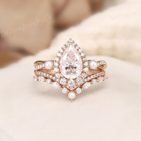 1.6 Carat Moissanite Engagement Ring Set with Infinity Engagement Band, Featuring a Unique Pearl Cluster and Twist Design. This Rose Gold Moissanite Ring Includes a Curved Stacking Band with Alternating Marquise Moissanite and Pearl Accents, Creating a Double Layered Wedding Band Set for Women, 2-Piece. ✦ Handmade, high-quality item ✦ Material: SOLID 10K/14K/18K GOLD ( can be made in yellow/white/rose gold ) ✦Engagement ring ✦ Center stone: Moissanite ✦ Size/Weight: 6*9mm ✦ Color: DEF color ✦ Cu Engagement Rings With Pearls Accents, Pearl Wedding Ring Set, Twist Wedding Ring, Wedding Ring Rose Gold, Rose Gold Moissanite Ring, Unique Engagement Ring Settings, Wedding Band Women, Stacked Wedding Bands, Moissanite Engagement Ring Set