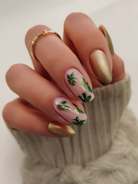 This sophisticated holiday nail design features a satin gold finish on almond-shaped nails, contrasted with delicate holly leaf and berry details on a neutral base. Perfect for those seeking a festive yet understated look, this design combines elegance with seasonal charm. Neutral Holiday Nails Almond, Satin Nails, Holiday Nails Almond, Neutral Holiday Nails, Holly Nails, November Christmas, Holiday Nail Designs, Shaped Nails, Holiday Nail