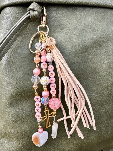 These handmade beaded keychains  are uniquely designed with high-quality beads, offering both style and functionality as a decorative accessory. This item is a great decor piece for your purse, wallet, dash mirror, keys, etc. Beautiful Faith Inspired Faith, Hope, and Love keychain with a cross charm.  A go-to gift for bridesmaids, Christian Women, or birthday gifts.  An awesome way to enhance the look of your favorite purse/bag/pocketbook! Looks fantastic with leather and just as nice with fabric.  These are a truly amazing addition to bridesmaid proposals, make great mother's day gifts, team gifts, teacher gifts and so much more! I would be happy to work with you if you have a specific personalization that isn't listed. Please message me via through my shop to work on an idividualized ite Beaded Keychain Ideas, Beaded Car Charms, Purse Charms Diy, Keychain Beaded, Purse Decorations, Leather Fob, Purse Keychain, Love Keychain, Keychain Craft