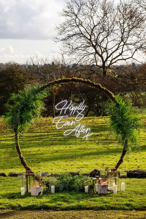 Moongate arches with neon signs. Could it get any better?. We love this Happily Ever After sign hanging inside our moongate arch. Using all foliage to create a luxurious botanical feel. The lanterns give off a great overall finished look. Neon Sign Hanging From Arch, Moongate Arch Wedding, Moongate Arch, Happily Ever After Sign, Wedding April, Moon Gate, Arch Decoration, Bright Wedding, Wedding Inside