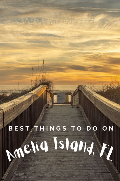 A wooden boardwalk is centered in the photograph at sunset. There is a wooden handrail on each sign. The water is calm and just beyond the boardwalk. The sky is golden and orange hued with wispy clouds and a tiny bit of blue. Amelia Island Florida Things To Do, Florida Trips, Fernandina Beach Florida, Beach Vacation Spots, Adventure Mom, Vacay Ideas, Amelia Island Florida, Thumbnail Sketches, Kissimmee Florida