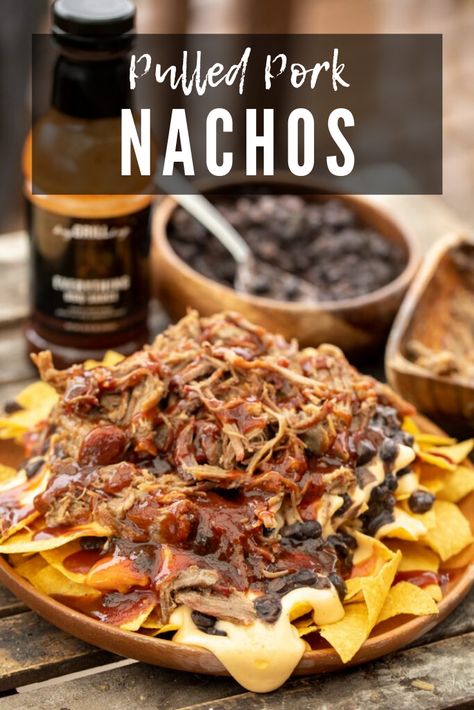 Pulled pork nachos are a delightfully messy pile of tasty flavors. Smoky pulled pork, tangy BBQ sauce, savory beans, and a creamy cheese sauce sit atop a mountain of crispy tortilla chips. Perfect for a simple family meal, tailgating snacks, or late night munching. Barbecue Nachos Pulled Pork, Bbq Nachos Recipe Pulled Pork, Unique Nachos, Tailgating Snacks, Pulled Pork Nachos Recipe, Pork Nachos Recipe, Bbq Nachos, Superbowl Recipes, Smoker Ideas