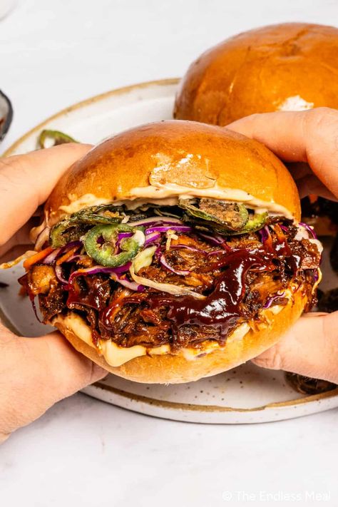 Sink your teeth into this BBQ pulled pork sandwich: savory, saucy, tender pork is nestled between warm brioche buns, with tangy slaw and satisfying crispy jalapeños for the perfect bite! The slow cooker does most of the work for you, making this the ultimate make-ahead meal for feeding a crowd or enjoying an effortless dinner! #theendlessmeal #sandwich #pork #pulledpork #pulledporksandwich #dinner #lunch Roast Pork Sandwich Recipes, Shredded Pork Sandwich Recipes, Tangy Slaw, Best Pulled Pork, Pork Sandwich Recipes, Roast Pork Sandwich, Pulled Pork Enchiladas, Bbq Pork Sandwiches, Pork Enchiladas