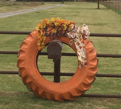 Tractor tire wreath Tractor Tire Pumpkin, Small Tire Projects, Pumpkin Tires, Tire Wreath Christmas, Tire Pumpkins, Tractor Tire Wreath, Tractor Tire Ideas, Hay Bale Decorating Ideas, Tire Wreath