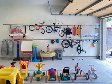 We’re huge fans of tucking things out of sight, but sometimes it makes more sense to store items out in the open. Dominque Caskey and the NEAT Method Houston team used both methods in this garage. How To Store Toys In Garage, Garage Organization Kids Stuff, Bike Wall Storage, Kids Garage, Outdoor Toy Storage, Garage Storage Inspiration, Christmas Decoration Storage, Elfa Shelving, Garage Storage Ideas