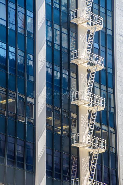 A white emergency stair for evacuation is attached to a high rise building. royalty free stock photos Fire Exit Stairs Design, Fire Exit Ladder Design, Emergency Stairs, Emergency Exit Stairs, Evacuation Center, Evacuation Plan, Building Photo, Abstract City, High Rise Building