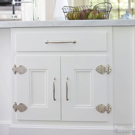 Exposed strap hinges rendered in a high-impact shape and a modern material partner with softly curved chrome pulls to beautifully update white-painted cabinets in a cottage-style kitchen. Note the recessed dual-paneled design that brings a handcrafted look and eye-catching depth to this pair of cabinet doors. Chicken Wire Cabinets, Paint Cabinets White, Cottage Kitchen Design, Cottage Style Kitchen, Update Cabinets, Cabinet Detailing, Best Kitchen Cabinets, Strap Hinges, Kitchen Refresh