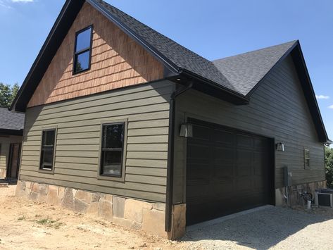 Olive House Black Trim, Green Brown And Black Exterior, Black Metal Siding House, Black Garage Doors Green House, Green Black And Cedar Exterior, Dark Green And Brown Exterior House Colors, Green House What Color Door, Sage Green House Exterior Black Trim, Roycroft Bronze Green Exterior House