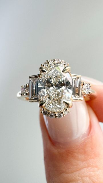 Alexis Gallery✨Custom Engagement Rings on Instagram: "Okay, we won’t lie. This was a fun one 💁‍♀️ ⁠We played with accent stone shapes and setting styles to channel that irresistible Gatsby vibe ✨⁠ ⁠ Featuring an oval centre stone with a half halo, paired with baguette and round side stones 🤌⁠ ⁠  ⁠ #engagementring #engaged #engagementrings #uniqueengagementring #customengagementring #diamondring #customjewelry #gatsbyvibe #vintagecharm #antique #engagementringinspo #engagementringidea  #antiquering #antqiuejewellery #weddingplanning #wedding #gettingmarried #engagementringtips #toronto ⁠ ⁠" Oval Engagement With Baguettes, Gatsby Style Engagement Ring, Oval Diamond Ring With Baguettes, Oval Engagement Ring With Tapered Baguettes, Oval Diamond With Baguettes, Oval Ring With Tapered Baguettes, Oval Tapered Baguette Engagement Ring, Oval Diamond Ring, Gatsby Style