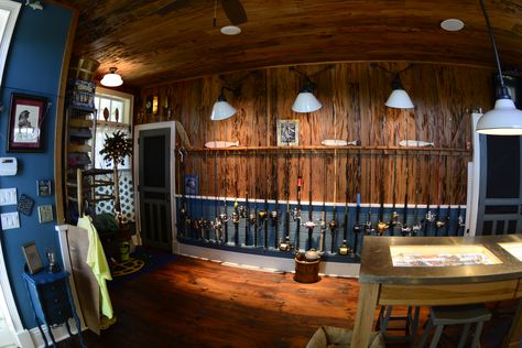 The perfect fishing rod storage in this custom tackle room.  The pecky cypress wall works beautifully with the rich blue wainscoting. Fishing Rod Wall, Old Florida Fish Camp Decor, Fishing Room Ideas, Fly Fishing Room, Fishing Storage Ideas, Fishing Workshop, Blue Wainscoting, Fishing Tackle Room, Fishing Room Decor