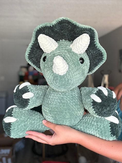 An adorable green colored triceratops! made with size 6 sweet snuggles lite yarn. pattern is tanner the triceratops by nichole chase! This dino sits at 16 in and stands at 20 in! Crochet Dino Triceratops, Colorful Crochet Animals, Crochet Land Before Time, Crochet Strawberry Dinosaur, Crochet Chunky Dinosaur Pattern Free, Green Crochet Plushies, Crochet Triceratops Free Pattern, Crochet Pterodactyl, Triceratops Crochet Pattern Free