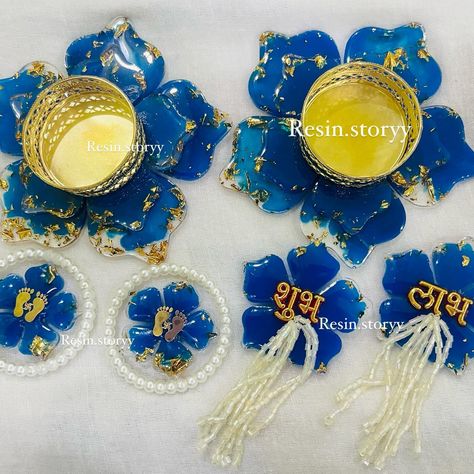 ✨ Diwali Special Resin Hampers ✨ Looking for the perfect blend of tradition and elegance? Our handmade resin hampers are just what you need! 💙 This set features: 🌸 Stunning flower tealight holders to light up your home. 🌸 Delicate Shubh Labh hangings for your entryway. 🌸 Pagaliya coasters adorned with pearl detailing, symbolizing auspicious beginnings. Each piece is crafted with love, gold accents, and a touch of luxury to elevate your festive decor. DM us for customizations and orders! 🕯️💫 ... Diwali Special, Festive Decor, Tealight, Tea Light Holder, Festival Decorations, Gold Accents, Diwali, Tea Lights, Light Up