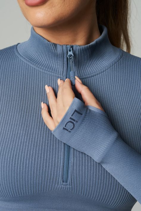 Customize your climate with the Seamless Ribbed Long Sleeve Half Zip. With long sleeves and a mock neck, this fitted pullover is exactly what you need for warm ups, cool downs and the stretches in between. The perfect fusion of performance and comfort. Our ribbed long sleeve is made from ultra-soft, premium fabric that is made to last. Full Coverage Double Lined Ribbed Fabric Half Zip Mock Neck Cropped Length Thumb Holes Ribbed Band Detail for Extra Support LiCi Logo placement center top back an Activewear Fabric Texture, Long Sleeve Activewear Tops, Tennis Dress Outfit, Sports Wear Outfits, Sporty Sweater, Blue Clothes, Gymwear Outfits, Long Sleeve Activewear, Running Wear